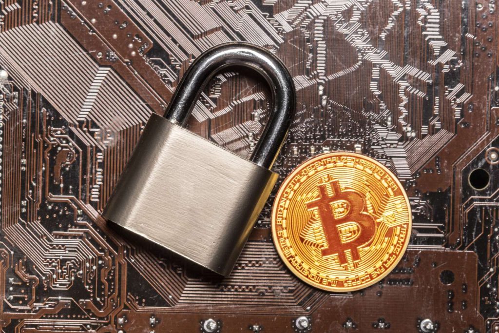 金色比特幣與掛鎖,象徵加密貨幣交易所安全問題的示意圖