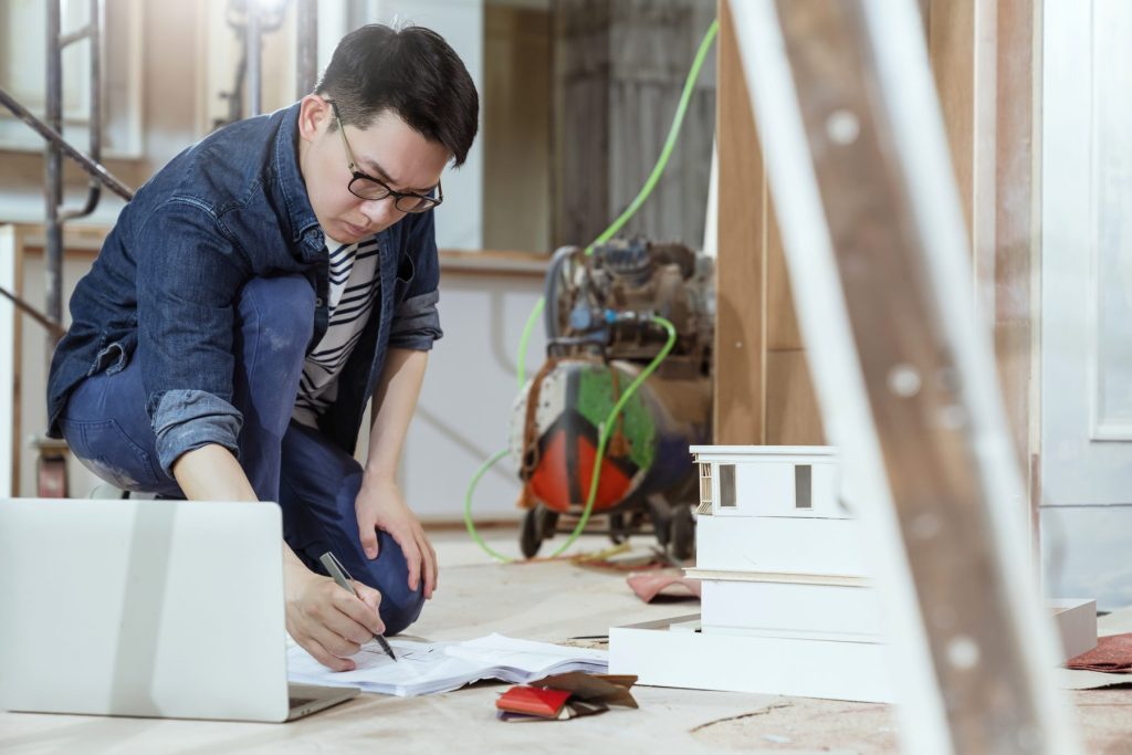 Portrait Young Asian Contractor Carpenter Site Checking Blueprint Floor With Concentrate Focus Home Renovate Site Construction Background