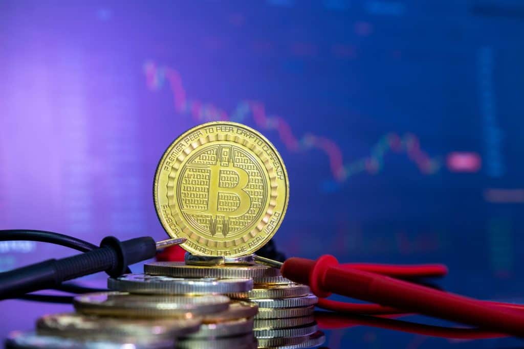 金色比特幣置於硬幣與長條圖之上的示意圖